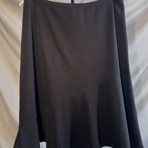 A black knee-length skirt with an asymmetric seam and a ruffled hem, hanging on a white hanger with clothespins.