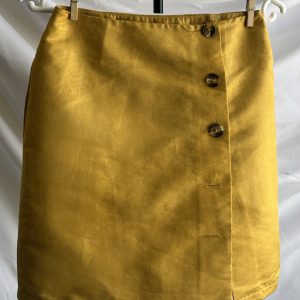 Gold satin mini skirt with a button-front wrap design, hanging on a white hanger against a white background.